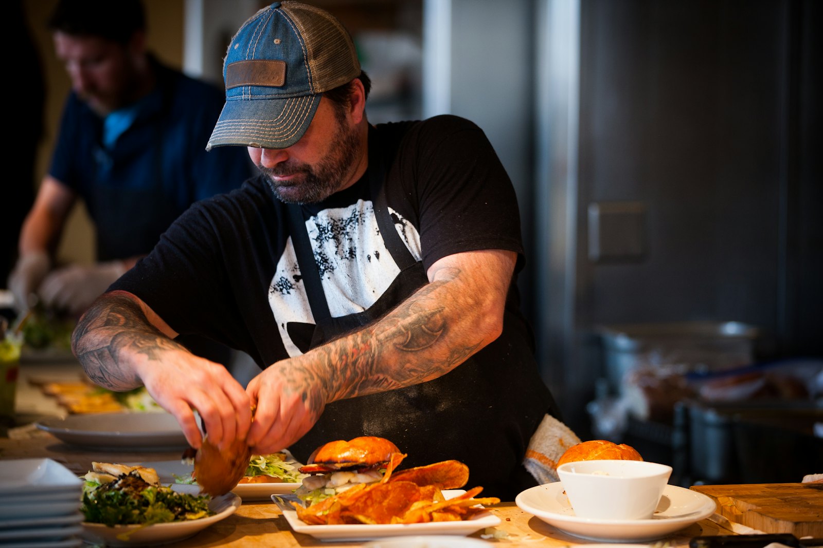 A chef finishing plates on the pass at Orlo