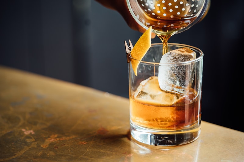 A negroni being poured over ice at the bar