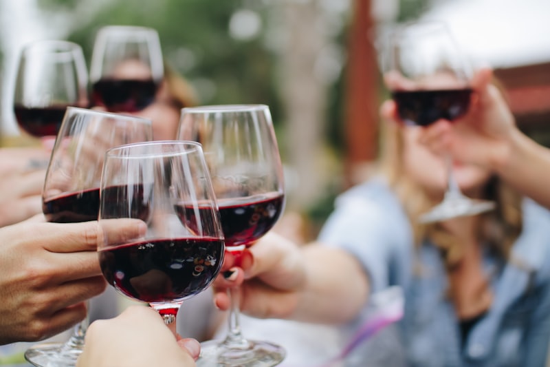 Glasses of red wine raised together at a table